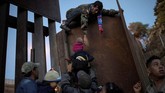 Sejumlah imigran dari Honduras berusaha menerobos pagar perbatasan antara Amerika Serikat dan Meksiko. (REUTERS/Alkis Konstantinidis TPX IMAGES OF THE DAY)