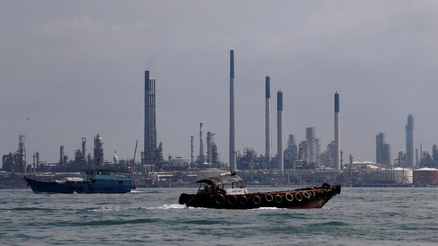 FILE PHOTO: Boats sail past Pulau Bukom oil refinery along the southern coast of Singapore June 8, 2016. REUTERS/Edgar Su/File Photo