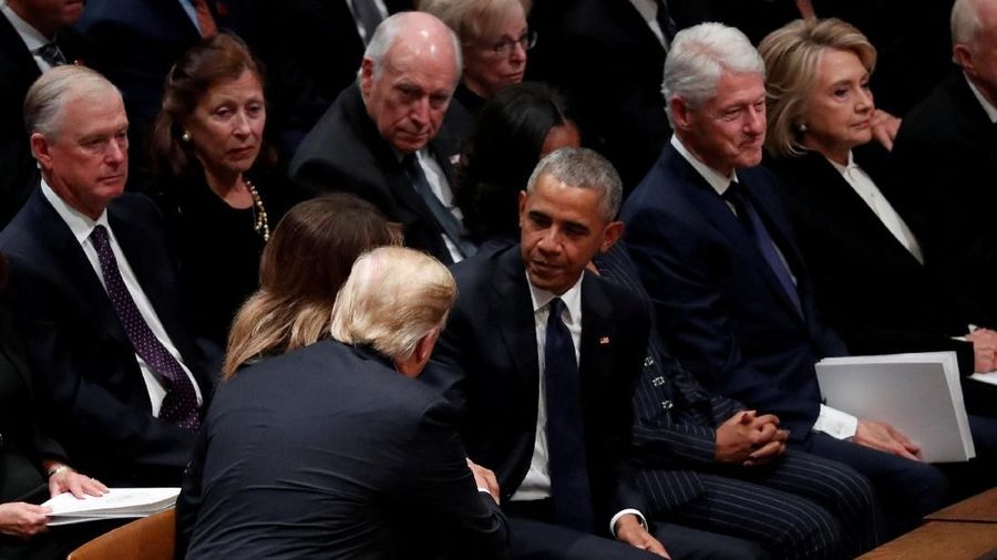 U.S. President Donald Trump reaches over to shake hands with former President Barack Obama as he takes his seat in the first row along with former first lady Michelle Obama, former President Bill Clinton and former first lady Hillary Clinton at the state funeral for former U.S. President George H.W. Bush at the Washington National Cathedral in Washington, U.S., December 5, 2018. REUTERS/Kevin Lamarque TPX IMAGES OF THE DAY