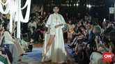 Gaun malam rancangan Bramanta menggunakan warna dasar putih dengan kain linen bercorak bunga klasik dari Eropa seperti krisan dengan nuansa biru, hijau, dan merah muda.