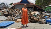 Nina Salilama berpose di depan rumahnya yang rusak akibat gempa dan tsunami di Wani, Donggala, Sulawesi Tengah. (ANTARA FOTO/Wahyu Putro A)