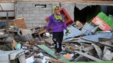 Lina berpose di depan rumahnya yang rusak akibat gempa dan tsunami di Lere, Palu, Sulawesi Tengah. Wapres RI Jusuf Kalla menyatakan proses rekontruksi di Palu akan fokus pada relokasi warga dan dimulai pada Januari 2019. (ANTARA FOTO/Wahyu Putro A)