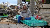 Suud Arrahman berpose di depan rumahnya yang rusak akibat gempa dan tsunami di Wani, Donggala, Sulawesi Tengah. (ANTARA FOTO/Wahyu Putro A)