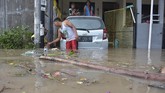 Seorang warga membersihkan sampah yang terbawa banjir di kawasan perumahan jalan Pura Demak, Denpasar, Sabtu (8/12). Hujan deras yang mengguyur wilayah Bali selatan pada Sabtu dini hari menyebabkan sejumlah kawasan di Denpasar terendam banjir sehingga sejumlah warga dievakuasi. (ANTARA FOTO/Adhi Prayitno/nym/hp).