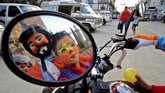 Gambar badut tercermin di kaca spion sebuah motor saat digelarnya Hari Badut Internasional di Guadalajara. (AFP/Ulises Ruiz)