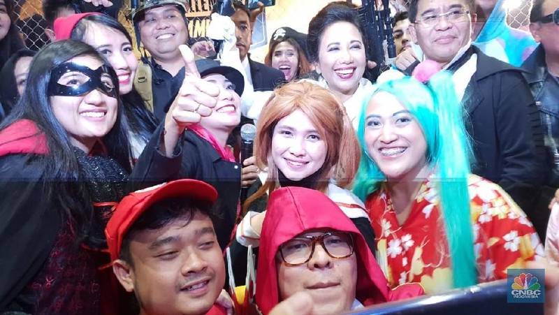 Gaya Menteri Rini datang dengan Jas Putih dasi oren dan membawa peralatan masakan.