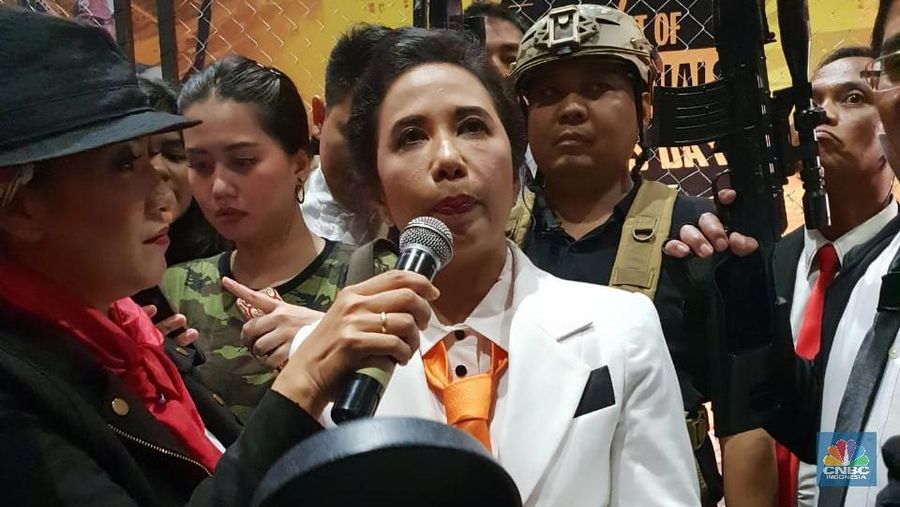Gaya Menteri Rini datang dengan Jas Putih dasi oren dan membawa peralatan masakan.