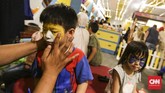 Pengunjung ikut mewarnai wajahnya jelang gelaran sirkus dari Oriental Circus Indonesia (OCI) yang bertajuk The Great 50 Show di kawasan GBK, Jakarta (12/12). (CNN Indonesia/ Hesti Rika)