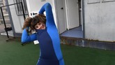 Lopez mengenakan wetsuit-nya sebelum melakukan latihan selancar di Pantai Salinas, Spanyol.