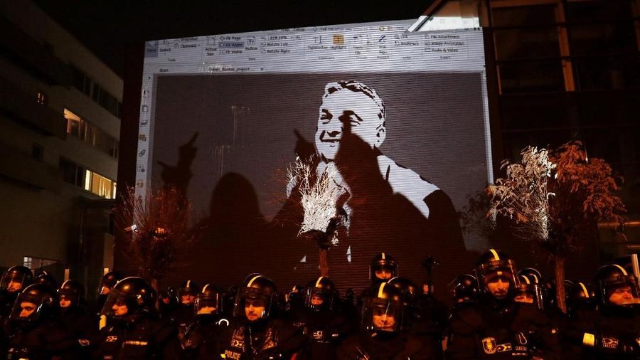 A drawing depicting Hungarian President Viktor Orban is projected on the wall of the TV building during a protest against a proposed new labor law, billed as the 