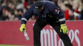 Petugas lapangan memungut botol yang dilempar ke arah Dele Alli. (Reuters/Andrew Couldridge)
