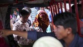 Sementara yang lain bersenda gurau, Akter hanya terdiam membawa koper, menunduk di tengah keriuhan. (Reuters/Mohammad Ponir Hossain)