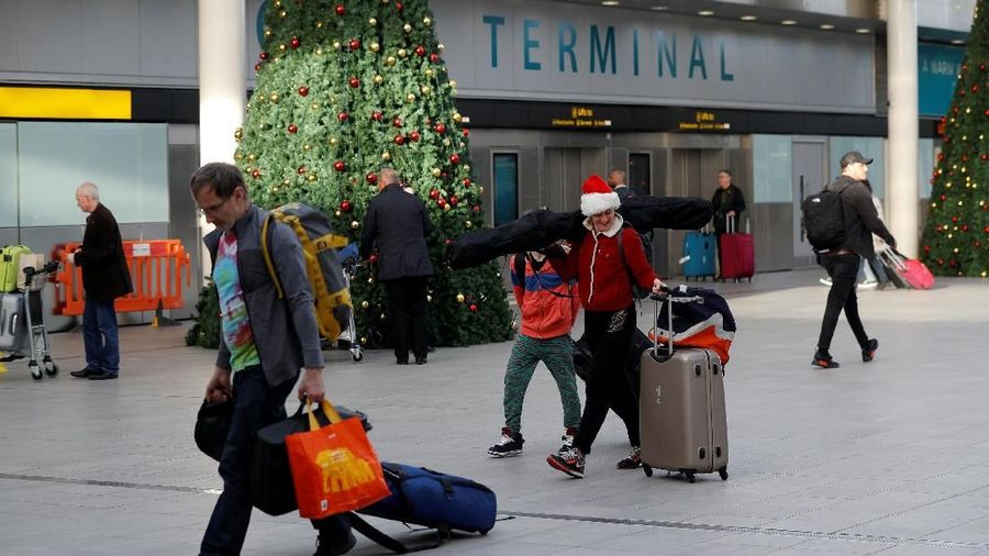 Passengers walk with suitcases in Gatwick Airport, in Crawley, Britain, December 22, 2018. REUTERS/Peter Nicholls