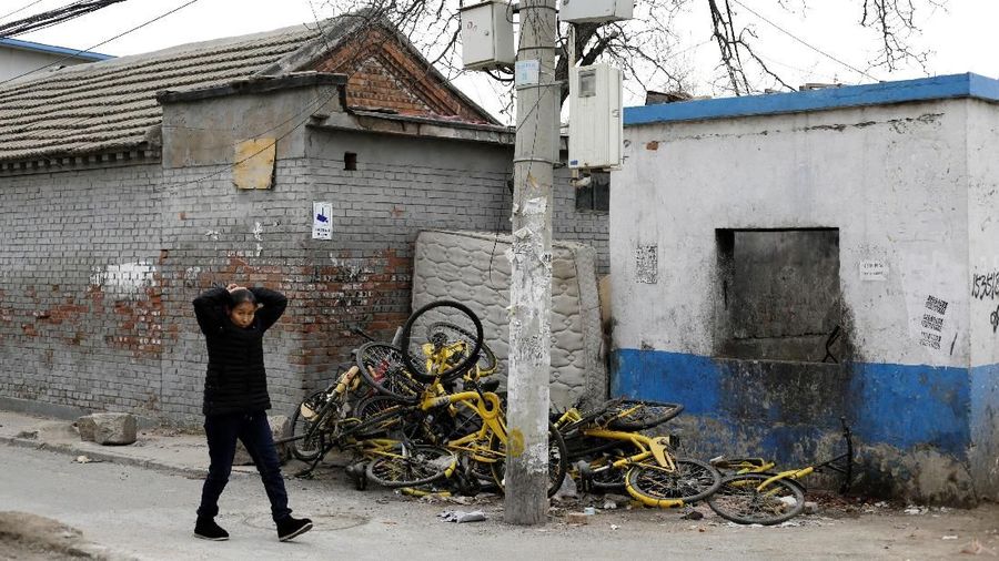 Sepeda Ofo rusak yang berbagi sepeda terletak di puing-puing di sebuah desa di pinggiran Beijing, Cina 22 Desember 2018. REUTERS / Jason Lee