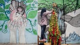 Warga menyelesaikan pembuatan instalasi pohon Natal berbahan limbah botol plastik di Purwosari, Solo, Jawa Tengah, Rabu (19/12). Mereka menghias kampung dengan membuat instalasi pohon Natal memanfaatkan limbah botol plastik untuk menyambut Natal 2018 sekaligus mengampanyekan gerakan peduli lingkungan. (Antara/Mohammad Ayudha)