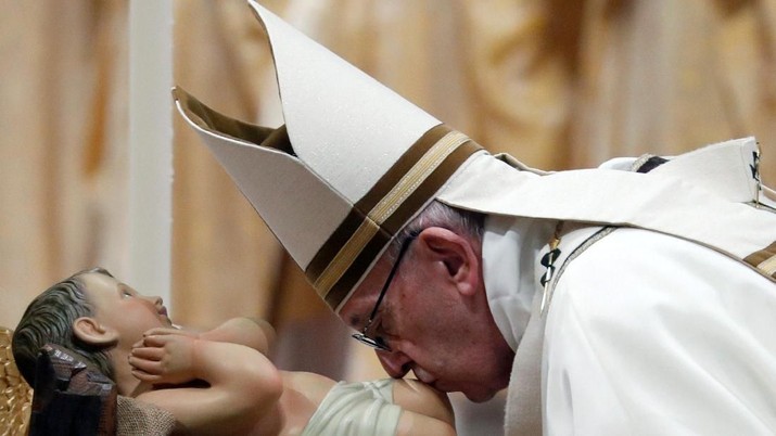 Paus Francis mencium patung bayi Yesus ketika ia memimpin misa Malam Natal di Basilika Santo Petrus di Vatikan, 24 Desember 2018. REUTERS / Max Rossi Pope Francis kisses a statue of baby Jesus as he leads the Christmas Eve mass in Saint Peter's Basilica at the Vatican, December 24, 2018. REUTERS/Max Rossi TPX IMAGES OF THE DAY