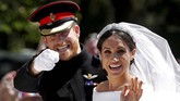 Pangeran Harry dan Meghan Markel menyapa warga dari kereta kuda setelah kebaktian pernikahan mereka di St George's Chapel di Windsor Castle di Winsor, Inggris, 19 Mei 2018. (REUTERS/Damir Sagolj)