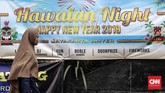 Warga melintas di depan spanduk perayaan malam tahun baru yang rencananya digelar sebuah hotel di kawasan Anyer, Banten, 28 Desember 2018. Sejumlah hotel yang telah mempersiapkan acara spesial akhir tahun terpaksa membatalkannya karena dampak bencana tsunami dan status siaga Gunung Anak Krakatau. (CNNIndonesia/Safir Makki)