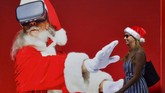 Seorang perempuan berjalan melewati poster raksasa Santa Klaus di pantai Jumeirah di Dubai. (GIUSEPPE CACACE / AFP)