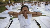 Seorang perempuan India berpartisipasi pada suatu sesi Yoga di Mahila Yoga Shakti Divas di Nikol, Ahmedabad. Lebih dari 700 perempuan berpartisipasi pada ajang yang digelar oleh Bhartiya Yoga Sansthan tersebut. (SAM PANTHAKY / AFP)