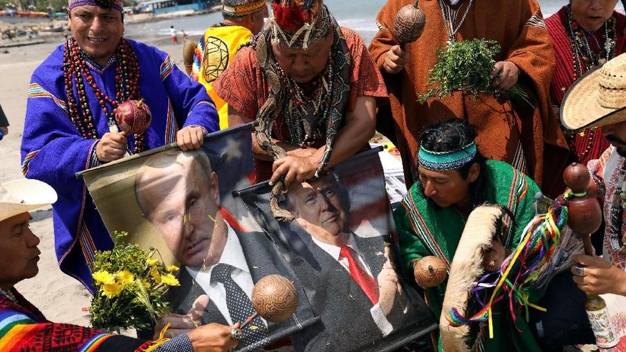 Peruvian shamans holding posters of Russian President Vladimir Putin, U.S. President Donald Trump and North Korean leader Kim Jong Un perform a ritual of predictions for the new year at Pescadores beach in Chorrillos, Lima, Peru December 27, 2018.  REUTERS/Mariana Bazo