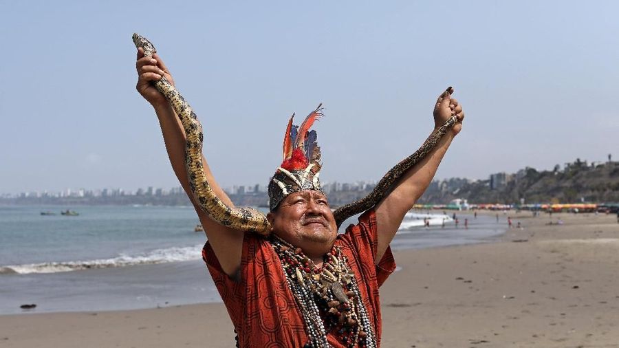 Peruvian shamans holding posters of Russian President Vladimir Putin, U.S. President Donald Trump and North Korean leader Kim Jong Un perform a ritual of predictions for the new year at Pescadores beach in Chorrillos, Lima, Peru December 27, 2018. REUTERS/Mariana Bazo