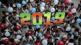 Pelajar memegang balon menyambut pesta pergantian tahun di sekolah mereka di Ahmedabad, India, Senin (31/12). (Reuters/Amit Dave)