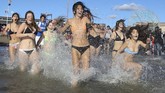 Warga negara Amerika Serikat berlari ke pantai yang berada di Pulau Conye di New York, saat mentari pertama di 2019 resmi bersinar. (REUTERS/Caitlin Ochs)