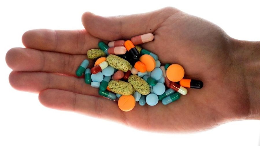 FILE PHOTO: A person holds pharmaceutical tablets and capsules in this picture illustration taken in Ljubljana September 18, 2013.  REUTERS/Srdjan Zivulovic/File Photo