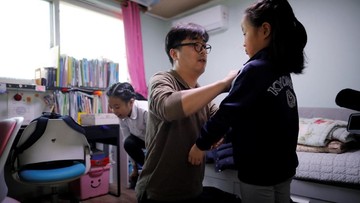 Kim Mi-sung checks her daughter's homework before leaving for school, at their home in Seoul, South Korea, December 19, 2018. Picture taken December 19, 2018.   REUTERS/Kim Hong-Ji
