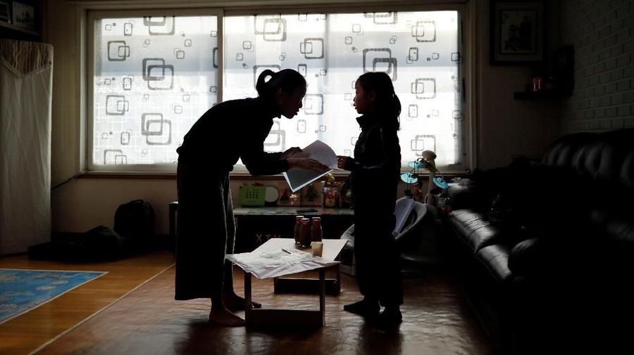 Kim Mi-sung checks her daughter's homework before leaving for school, at their home in Seoul, South Korea, December 19, 2018. Picture taken December 19, 2018.   REUTERS/Kim Hong-Ji