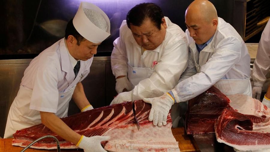 Kiyomura Co's President Kiyoshi Kimura (C), who runs a chain of sushi restaurants Sushi Zanmai, cuts a 278kg bluefin tuna, priced with a 333,600,000 yen bid at the Toyosu fish market's first tuna auction this year, at his sushi restaurant in Tokyo, Japan, January 5, 2019. REUTERS/Kim Kyung-Hoon