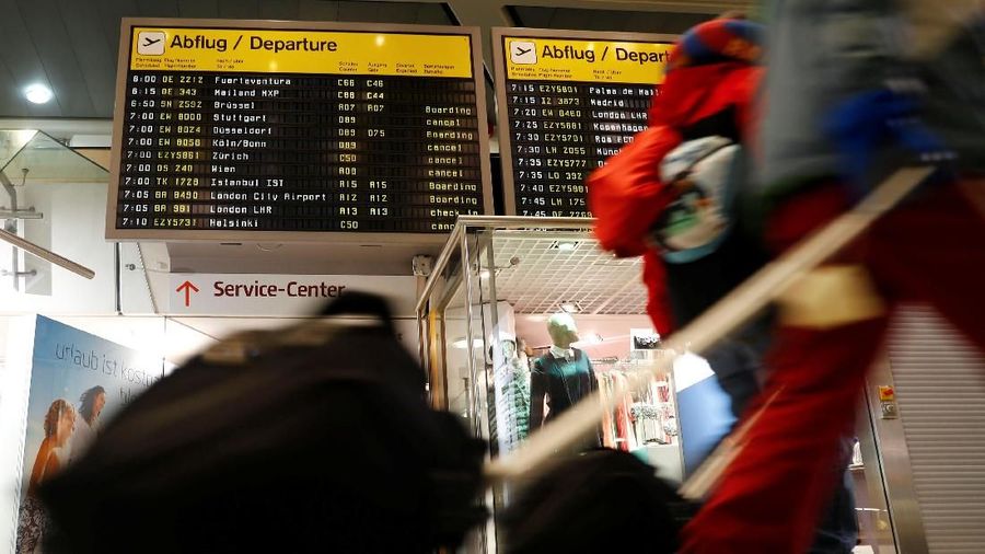 Passengers walk past a display panel as members of Germany's Verdi union take part in a strike by ground security inspection staff at Tegel airport in Berlin, Germany, January 7, 2019.    REUTERS/Fabrizio Bensch