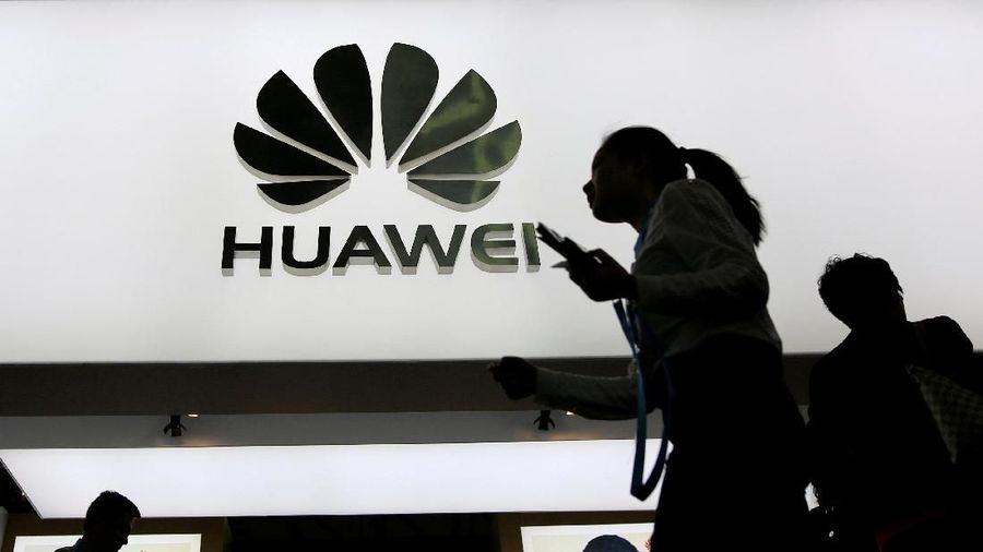 FILE PHOTO: People walk past a sign board of Huawei at CES (Consumer Electronics Show) Asia 2016 in Shanghai, China May 12, 2016. REUTERS/Aly Song/File Photo
