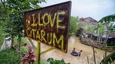 Dua orang anak bermain saat banjir di Kampung Bojong Asih, Desa Dayeuhkolot, Kabupaten Bandung,6 Maret 2018. Untuk menanggulangi banjir, Pemprov Jabar menggunakan segala cara termasuk lewat pembangunan kolam retensi Cieunteung. (ANTARA FOTO/Raisan Al Faris)