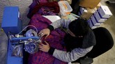 Seorang penjahit Palestina menjahit thobe di sebuah pabrik di Ramallah. (REUTERS/Raneen Sawafta)