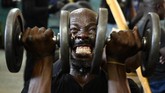 Seorang pria mengangkat beban saat berolahraga di sebuah pusat kebugaran di Nairobi, Kenya. (AFP/Simon Maina)