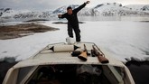 Salah seorang warga di kota Tasiilaq, naik kapal untuk mencari telur burung puffin, salah satu dari sekian banyak mata pencarian penduduk di Greenland.