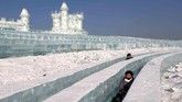 Para pengunjung berada di antara patung-patung es di festival es di Harbin, Provinsi Heilongjiang, China. (Reuters/Tyrone Siu)