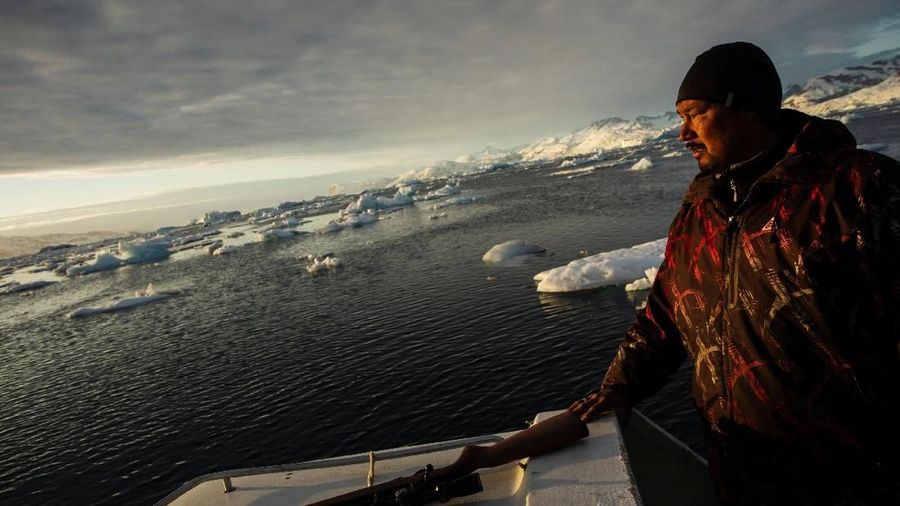 Seal hunter Henrik Josvasson jumps back onto his boat after searching for puffin eggs near the town of Tasiilaq, Greenland, June 16, 2018. REUTERS/Lucas Jackson  SEARCH 