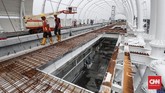 Pekerja menyelesaikan proyek stasiun kereta api ringan (Light Rail Transit/LRT) di Stasiun LRT Taman Mini, Jakarta, Senin (14/1). (CNNIndonesia/Safir Makki).