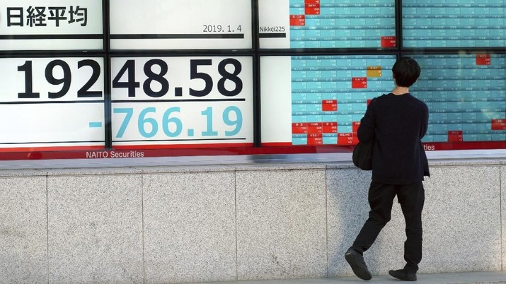 A man looks at an electronic stock board showing Japan's Nikkei 225 index at a securities firm in Tokyo Friday, Jan. 4, 2019. Japanese markets have tumbled as they reopened after the New Year holidays, while other Asian indexes are mixed after a technology-led sell-off on Wall Street. (AP Photo/Eugene Hoshiko)
