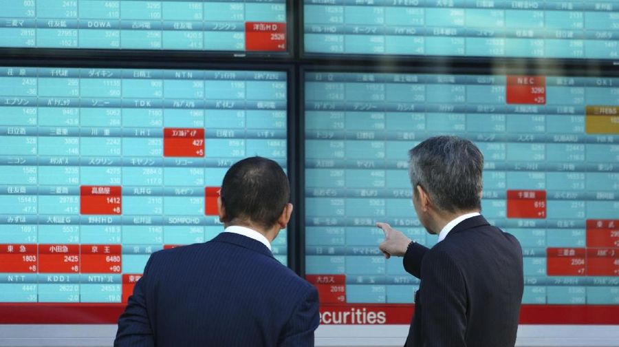 Men look at an electronic stock board showing Japan's Nikkei 225 index at a securities firm in Tokyo Friday, Jan. 4, 2019. Japanese markets have tumbled as they reopened after the New Year holidays, while other Asian indexes are mixed after a technology-led sell-off on Wall Street. (AP Photo/Eugene Hoshiko)