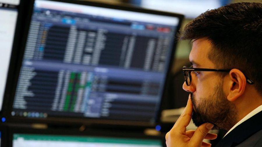 Traders work at their desks whilst screens show market data at CMC Markets in London, Britain, January 16, 2019. REUTERS/John Sibley