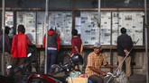 Warga membaca koran yang dipajang di Papan Baca Monumen Pers Nasional, Solo, Jawa Tengah. (ANTARA FOTO/Maulana Surya)