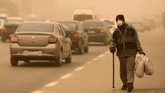 Penduduk Kairo yang terpaksa harus beraktivitas di luar ruangan di tengah badai pasir harus mengenakan masker dan jaket. (REUTERS/Mohamed Abd El Ghany)