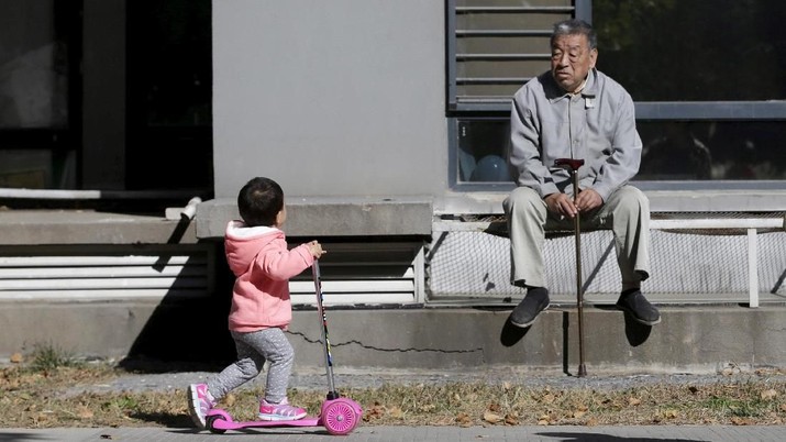 Populasi China (Reuters/Jason Lee) FILE PHOTO: An 80-year-old man, surnamed Li, watches as a girl plays at a residential community in Beijing, China, October 30, 2015. REUTERS/Jason Lee/File Photo