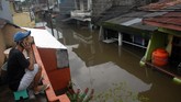 Warga menelpon diatas rumahnya saat banjir di Kecamatan Manggala, Makassar, Sulawesi Selatan, Rabu (23/1/2019). Akibat diguyur hujan dalam beberapa hari sejumlah daerah di Makassar terendam banjir. (ANTARA FOTO/Abriawan Abhe/foc)