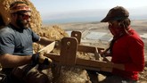 Para relawan dan arkeologis bekerja dengan menggali gua-gua kecil di dekat area Qumran pada 15 Januari 2019. (REUTERS/Ronen Zvulun)