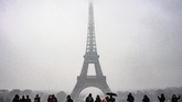 Walau diguyur salju lebat, namun turis masih terlihat menyemut di Menara Eiffel, Paris, Prancis. (Photo by Lionel BONAVENTURE / AFP)